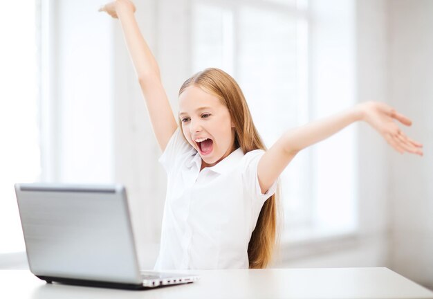 education-school-technology-and-internet-concept-happy-little-girl-with-laptop-pc-at-school_380164-39739